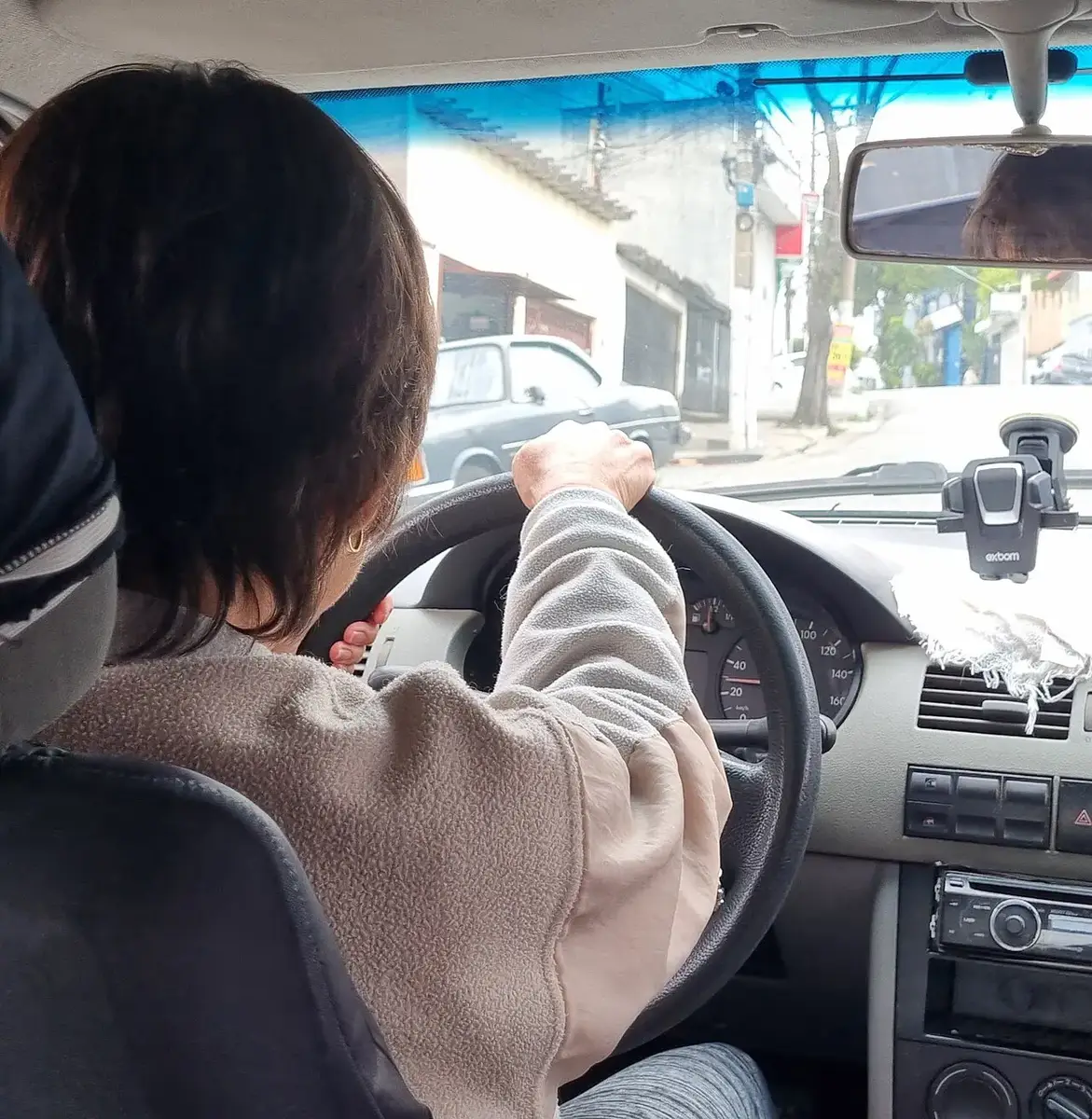 Motorista dirigindo com o celular no suporte